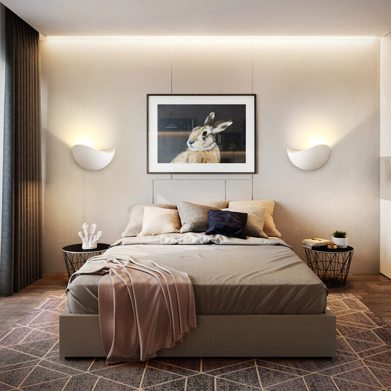 Modern bedroom with a bed, wall art of a rabbit, and side tables.