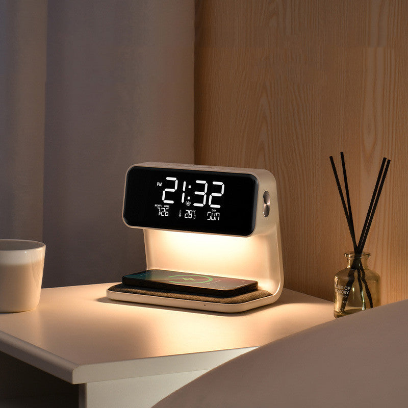 Digital clock with wireless charging pad on a bedside table