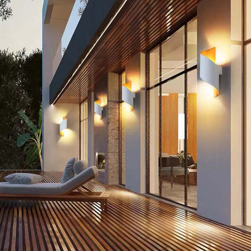 Modern outdoor patio with lounge chair, glass walls, and evening lighting