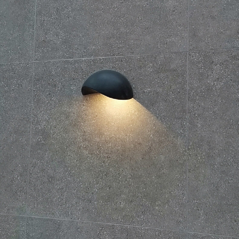 Black outdoor wall light fixture on a gray concrete wall