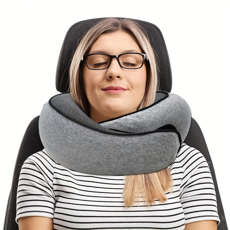 Woman using a gray neck pillow in a car seat with a small black bag beside her.