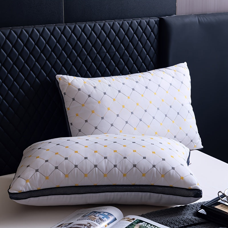 Two white pillows with geometric patterns on a bed with a dark headboard.