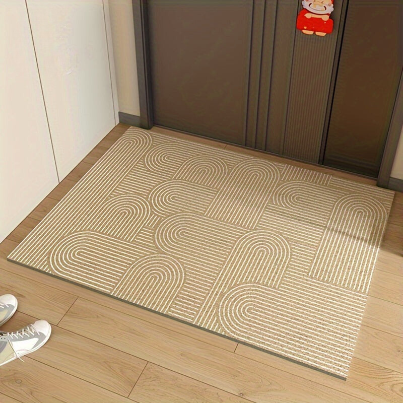 Beige doormat with arch pattern on a wooden floor, next to a closed door.