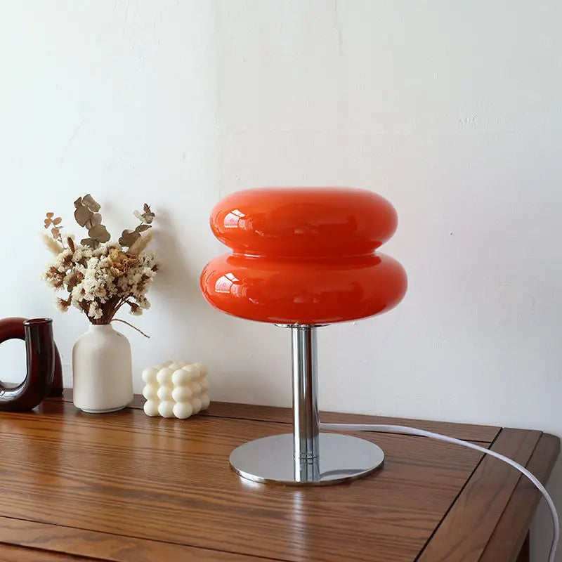 Orange stool with a white cable on a wooden surface against a white wall