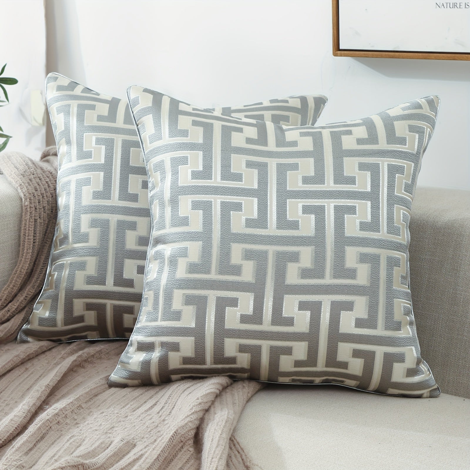 Two patterned pillows on a sofa with a neutral background