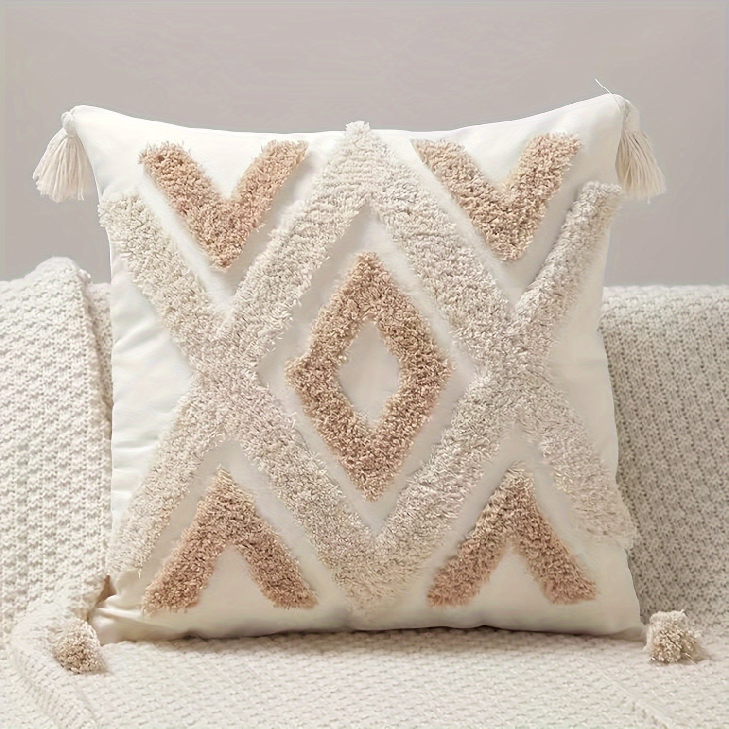Decorative pillow with geometric pattern and tassels on a neutral background