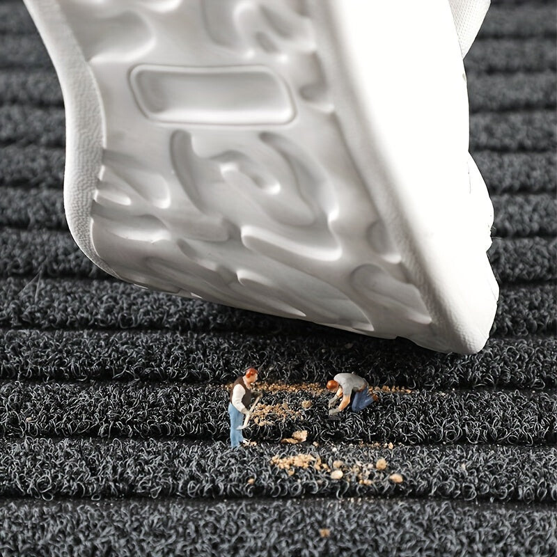 Close-up of a white shoe sole on a textured black surface with small figures working on it.