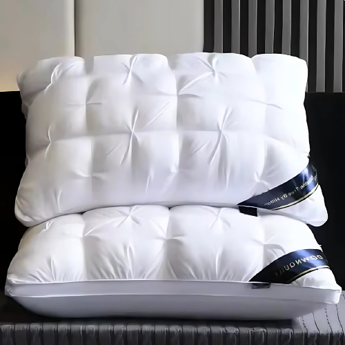 Two white pillows on a bed with a headboard and decorative elements.