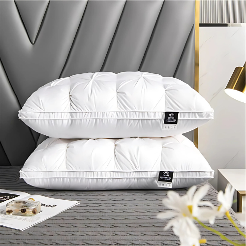 Two white pillows on a bed with a headboard and decorative elements.