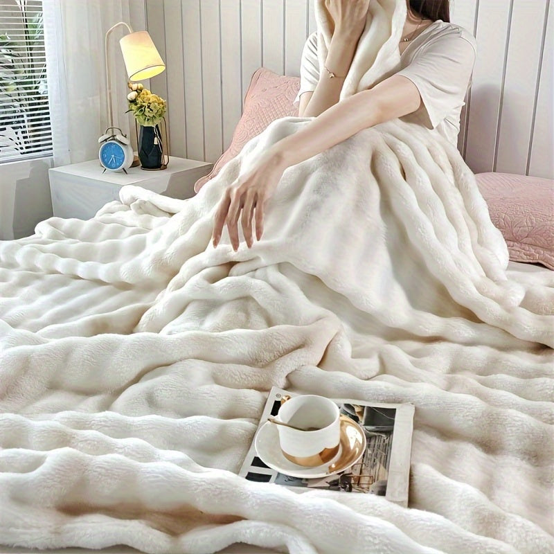 Person wrapped in a soft white blanket in a cozy room with a lamp and clock.