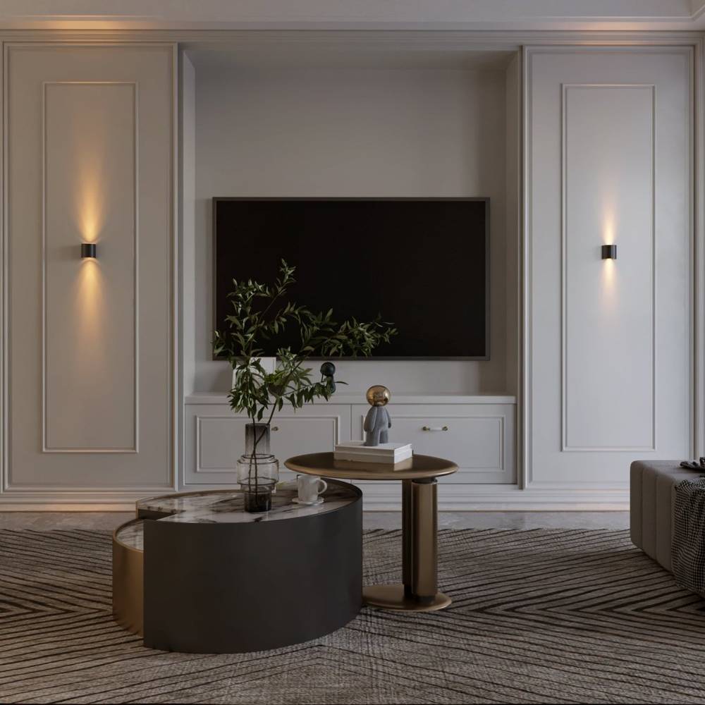 Modern living room with a television mounted on a wall, two round tables, and decorative items.