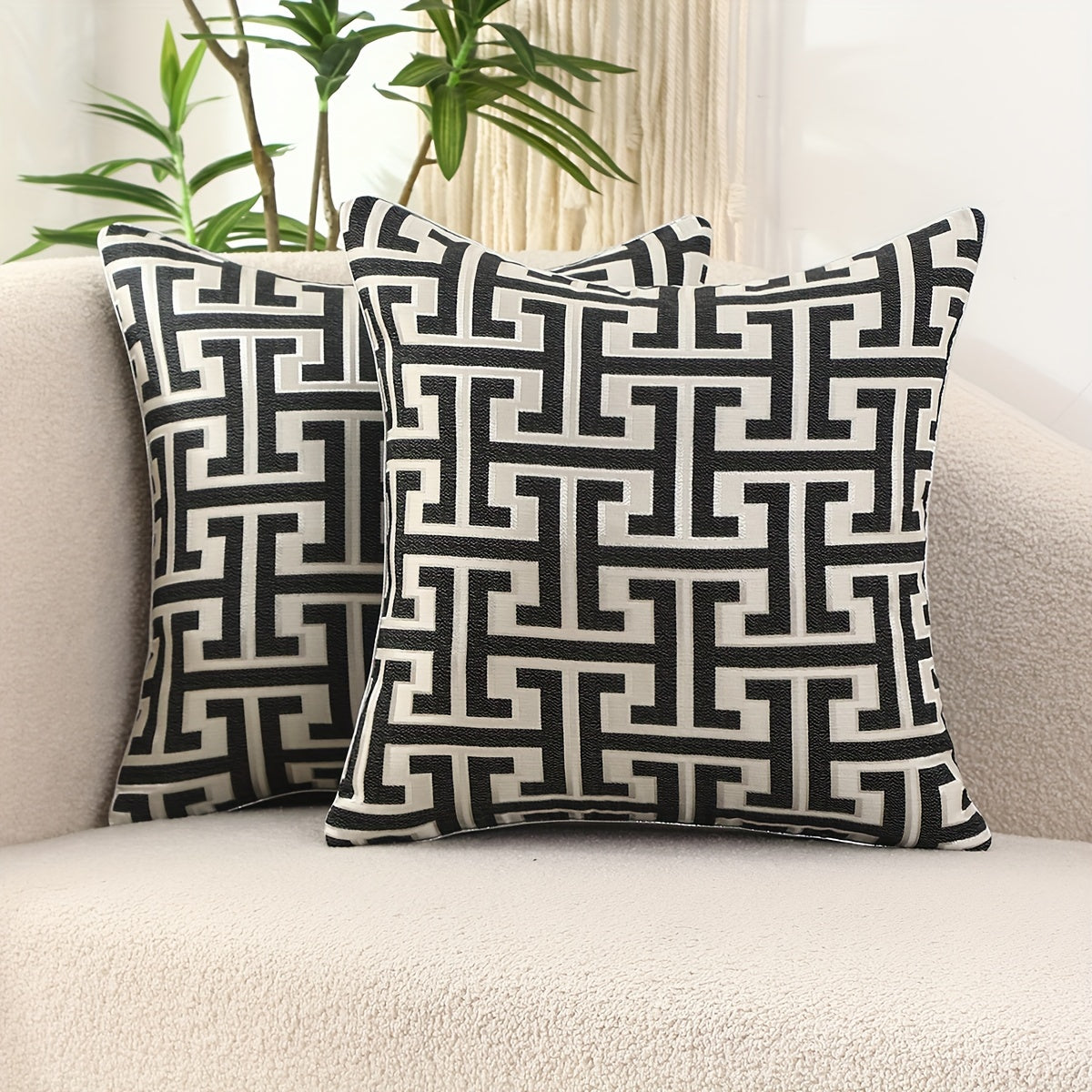Two decorative pillows with a geometric pattern on a couch.