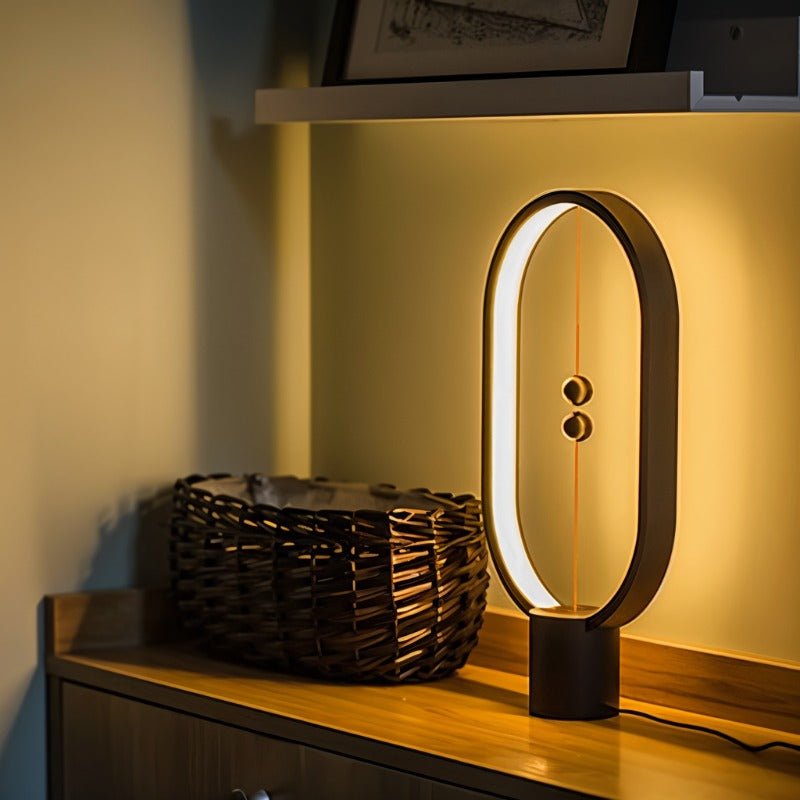 Modern table lamp with a unique design on a wooden surface, emitting a warm glow.