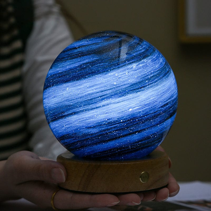 Blue glowing sphere on a wooden base held by a person