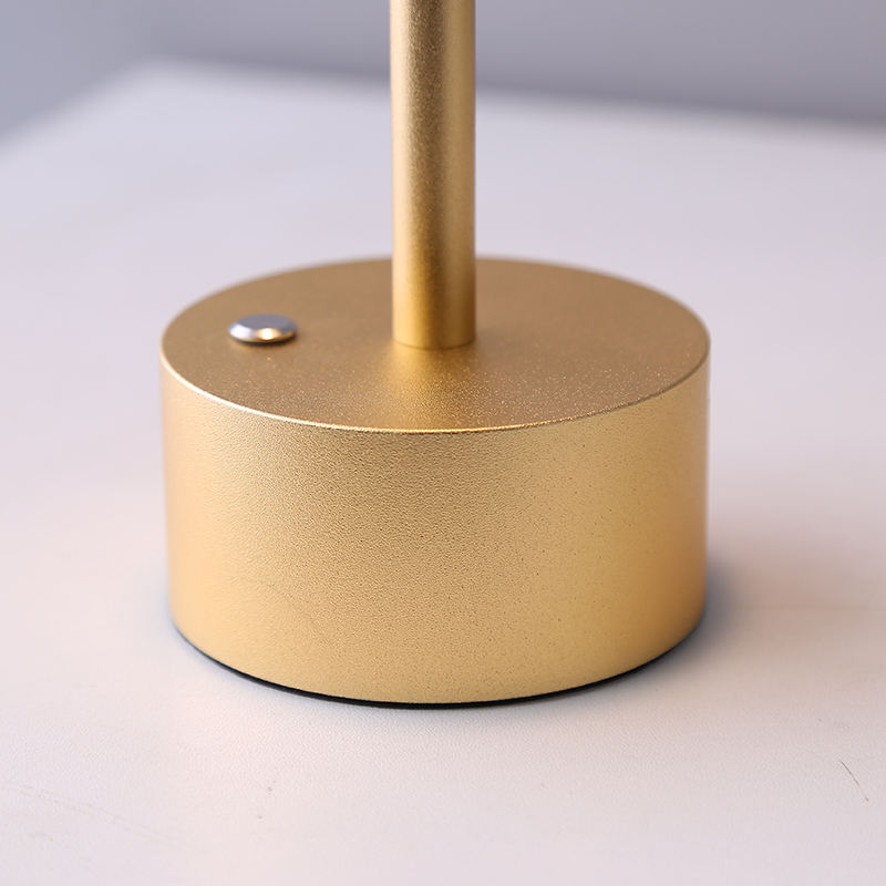 Gold-colored lamp base on a light gray background