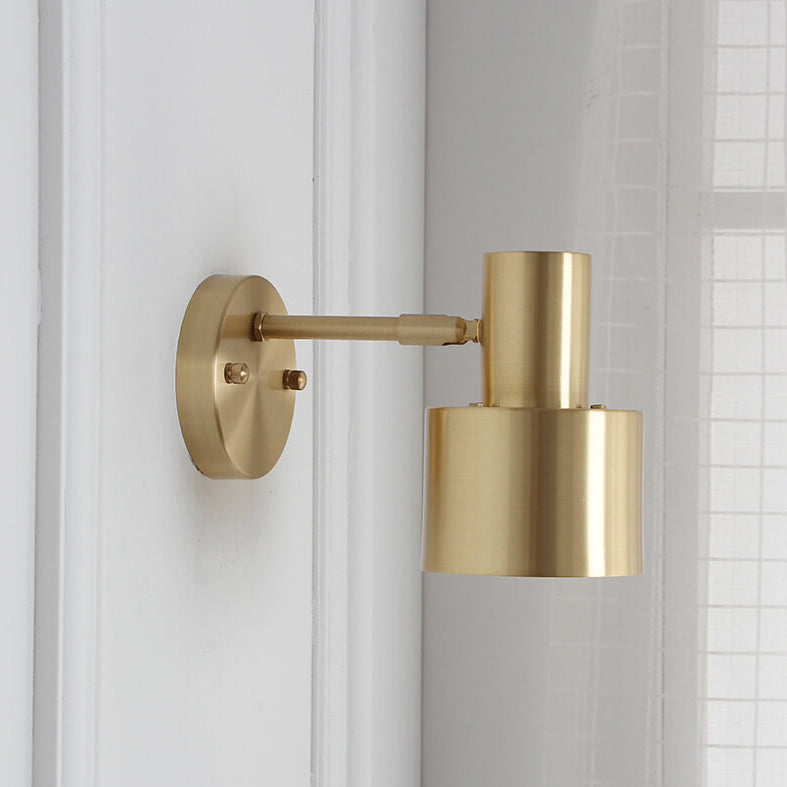 Gold wall-mounted lamp on a white wall with a tiled background