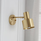 Gold wall-mounted lamp on a white wall