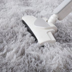White vacuum cleaner cleaning a gray carpet