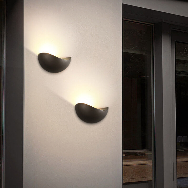 Two modern wall lights on a white wall with a dark interior setting.