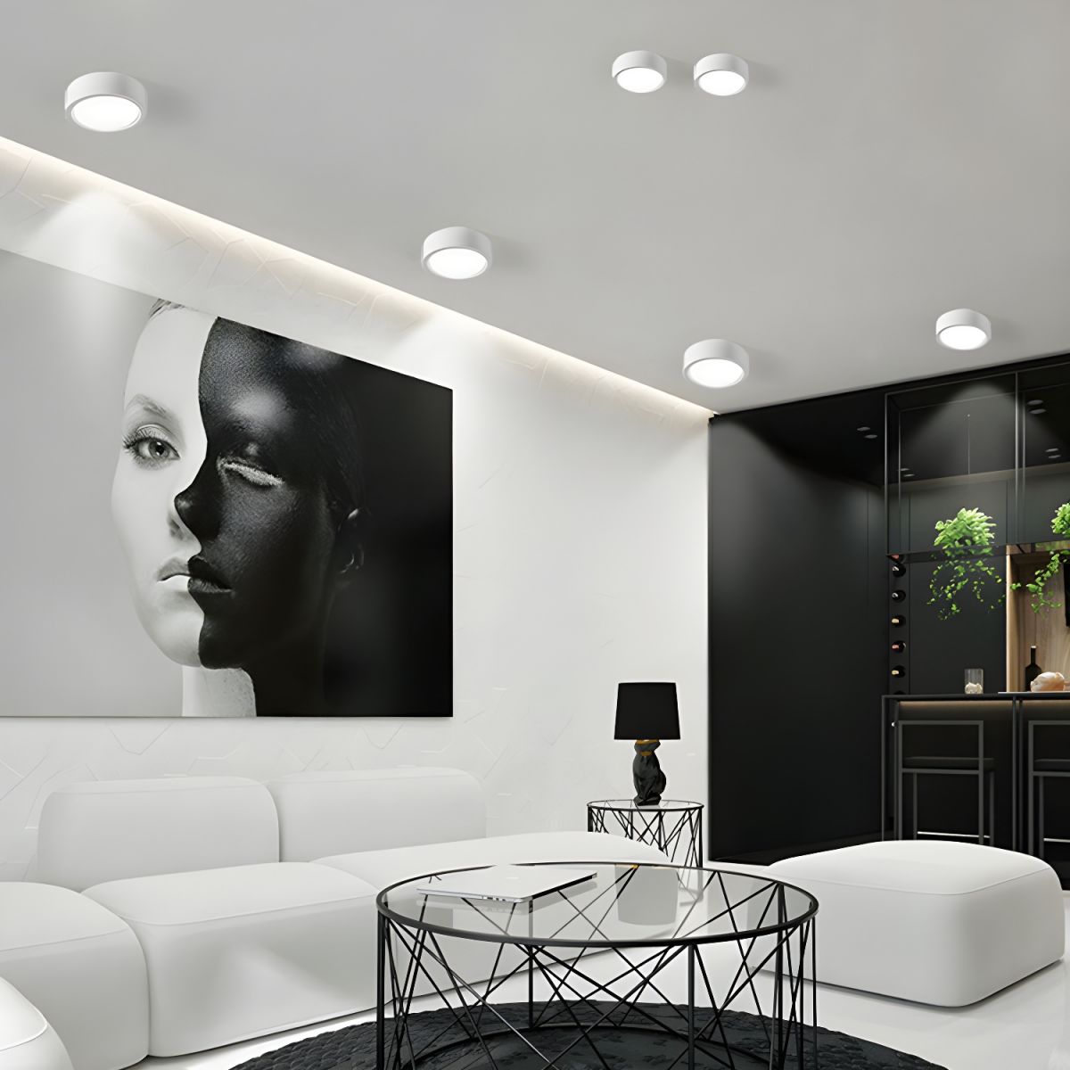 Modern living room with a black and white portrait on the wall, white sofa, and glass coffee table.