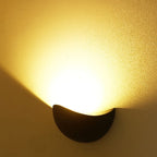Wall-mounted light fixture casting a warm glow on a textured wall.