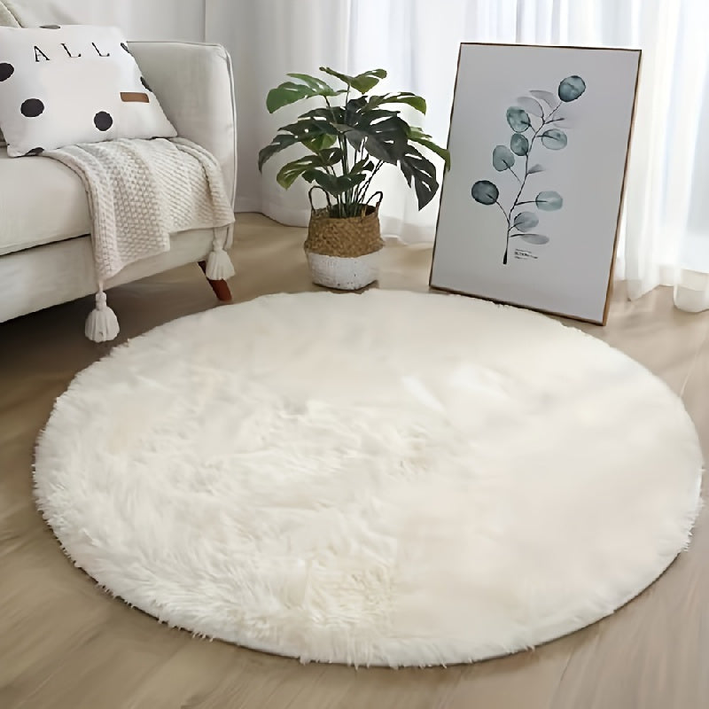 Round white fluffy rug in a living room with a sofa, plant, and artwork.