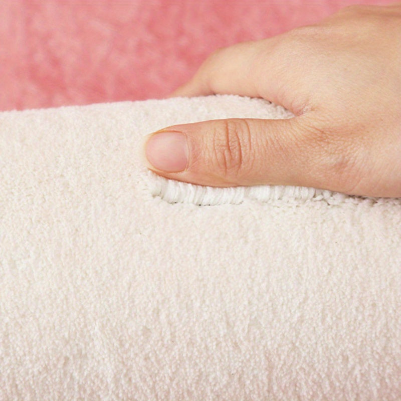 Close-up of a hand holding a textured white fabric against a pink background