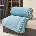 Rolled blue blanket on a chair in a room with curtains and a table.