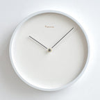 White wall clock with black hands on a white background
