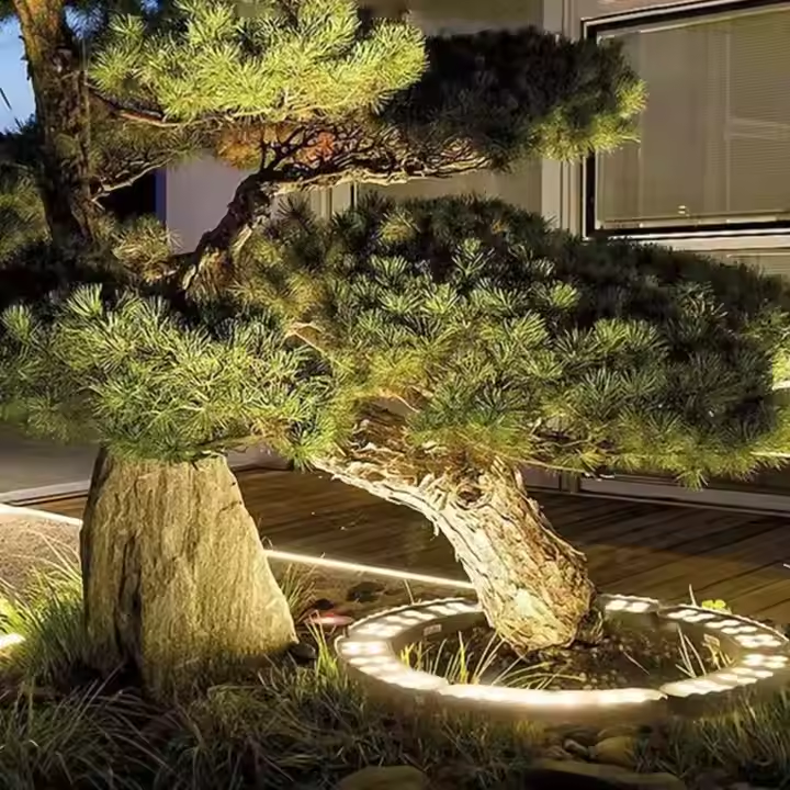 Bonsai tree in a pot on a wooden deck with a stone base