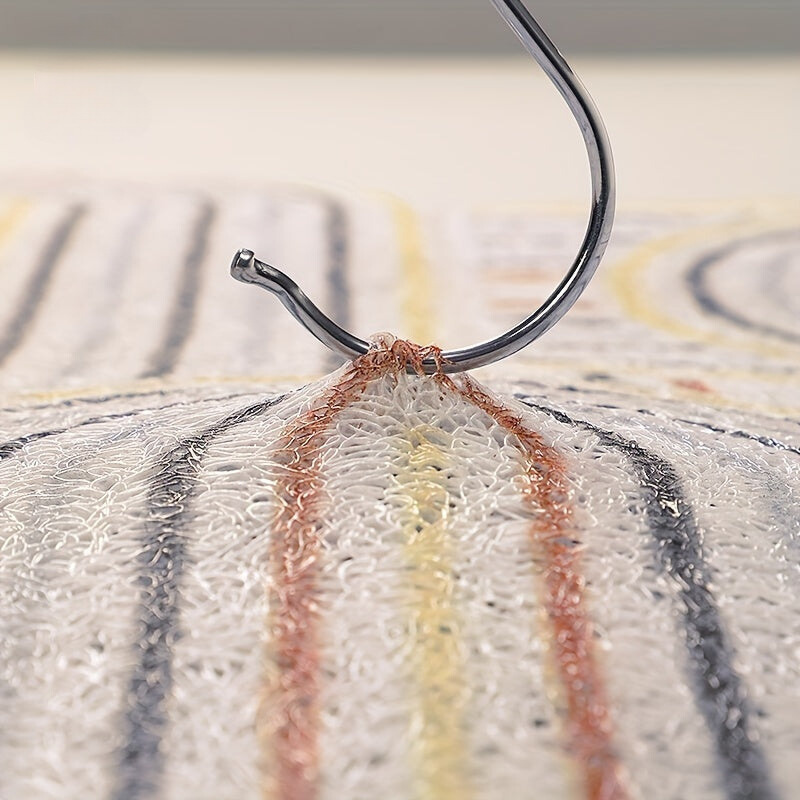 Close-up of a fishing hook on a striped fabric background