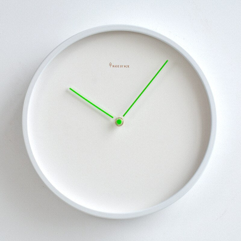 White wall clock with green hands on a white background