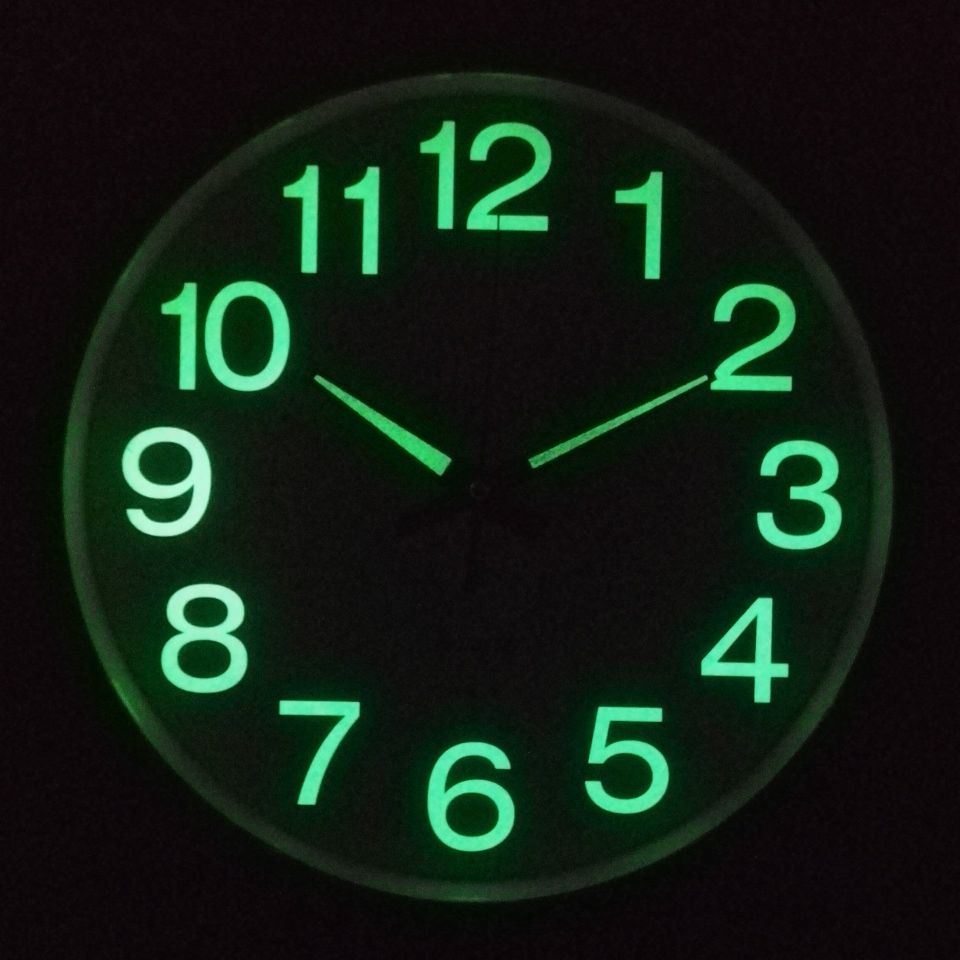 Glowing green clock face on a black background