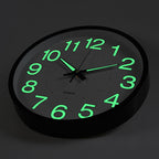Wall clock with green glowing numbers on a black background
