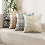 Decorative pillows with geometric patterns on a beige sofa.