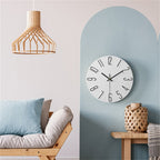 Modern interior with a wooden pendant light, round wall clock, and a sofa against a light blue wall.