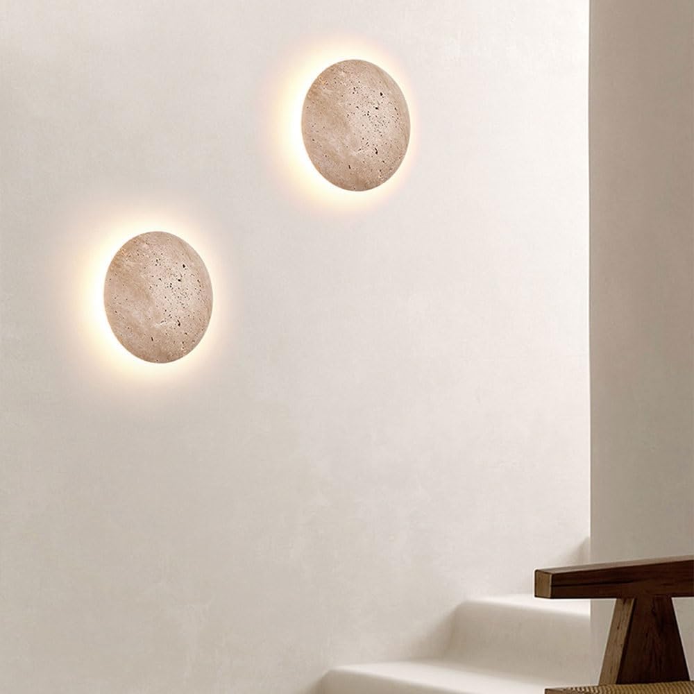Two round wall lights on a textured wall.