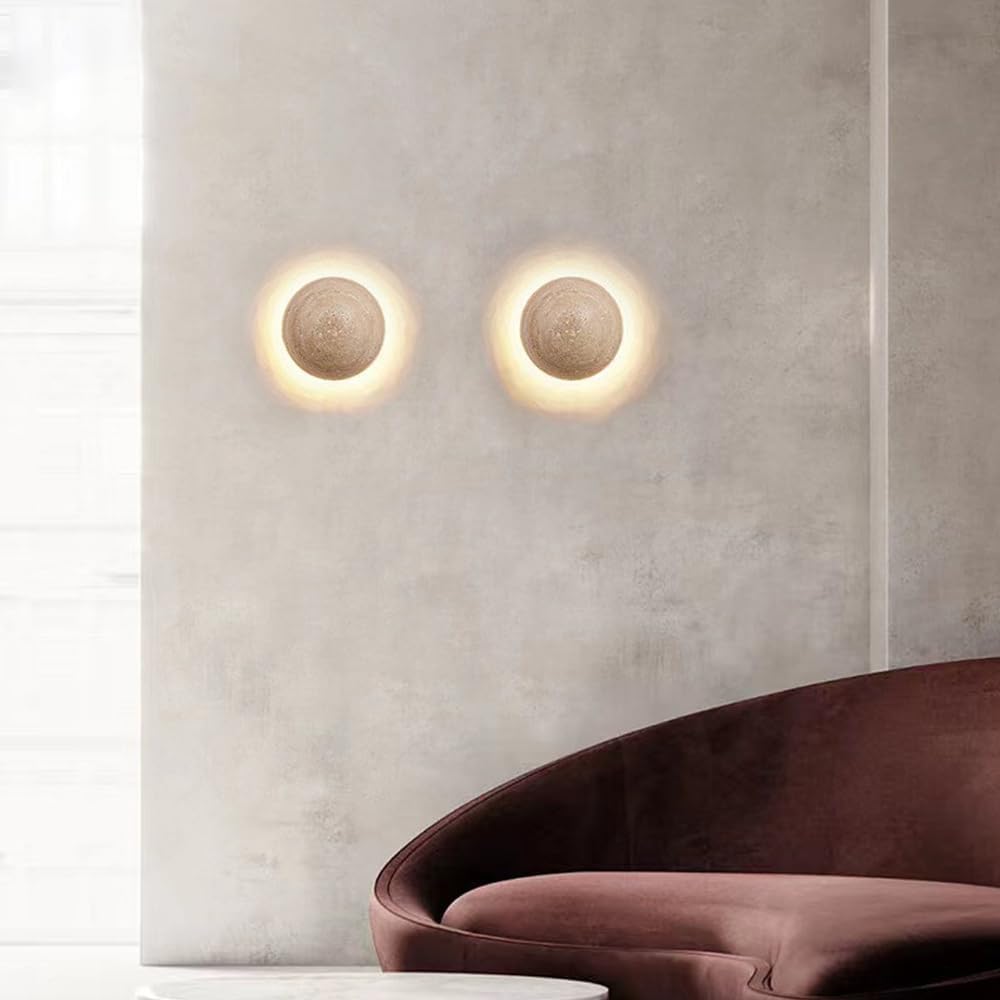 Two round wall lights on a textured wall with a modern sofa in the foreground.