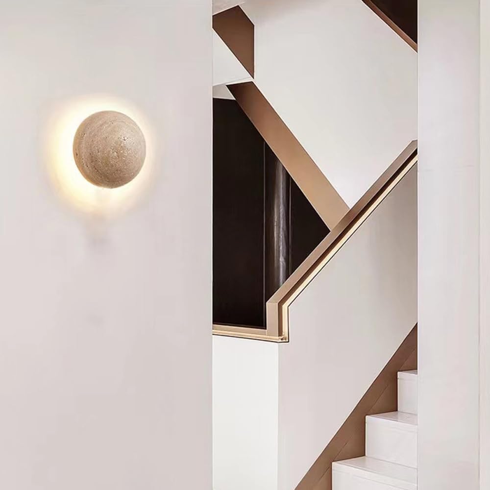 Modern wall light fixture on a white wall next to a staircase with wooden railings.