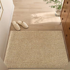 Beige doormat on a wooden floor with white slippers and a plant in the background