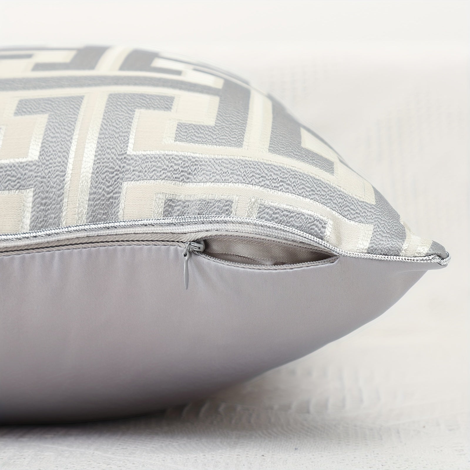 Gray pillow with geometric pattern on a white background