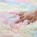 Close-up of a hand touching a fluffy, multicolored blanket.
