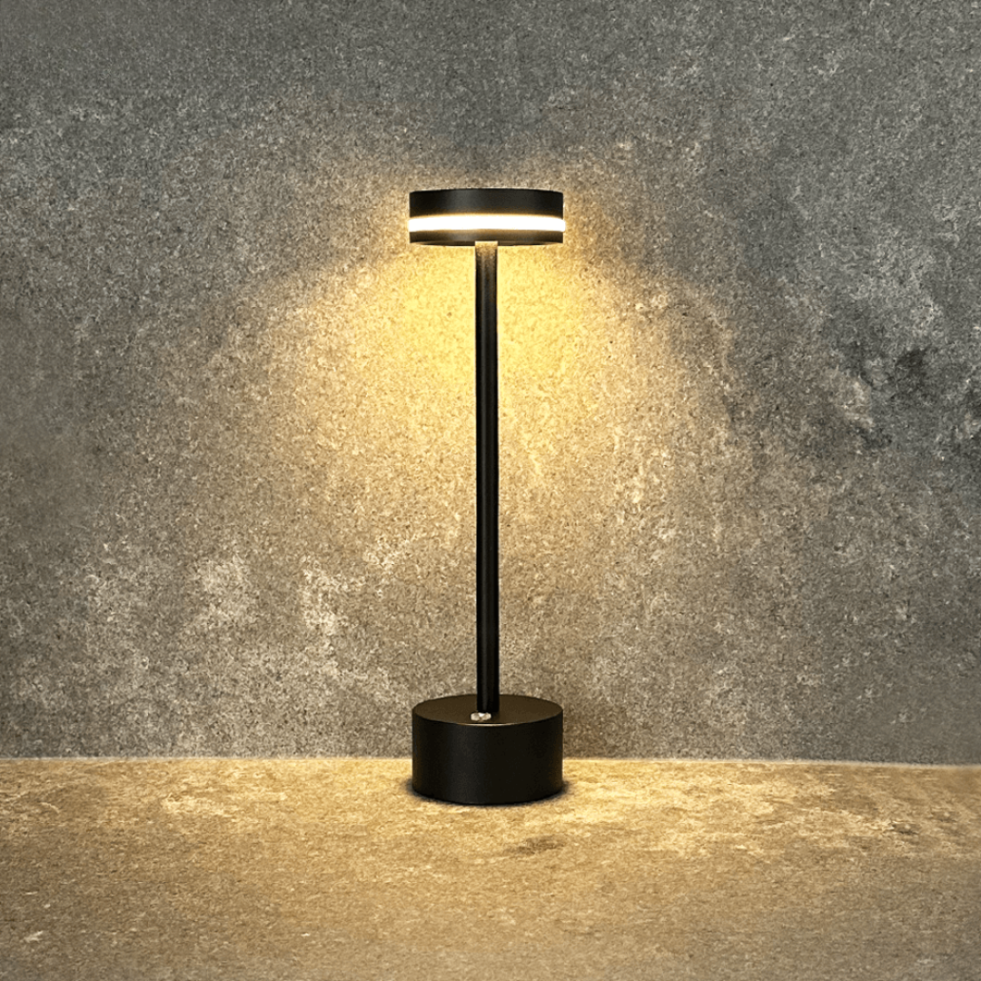 Black outdoor lamp with a warm glow on a textured gray background