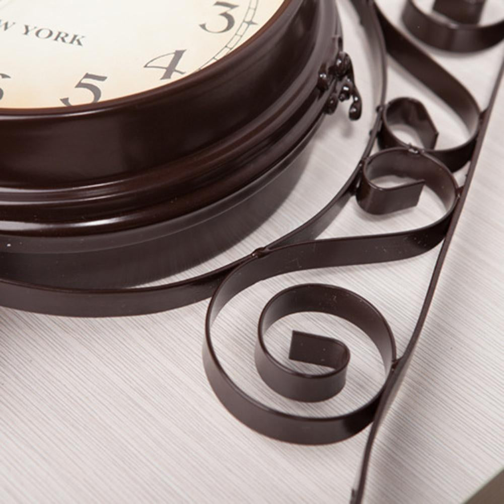 Decorative wall clock with intricate metal design on a light background