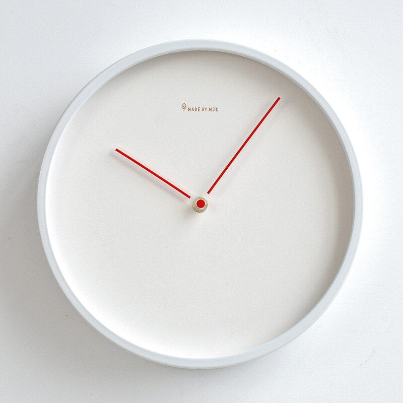 White wall clock with red hands on a white background