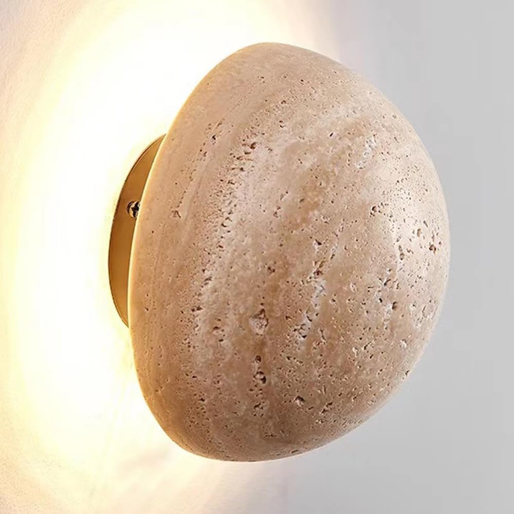 Round stone-like wall sconce with gold fixture on a light gray background