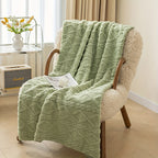 Green textured blanket draped over a chair in a cozy room.