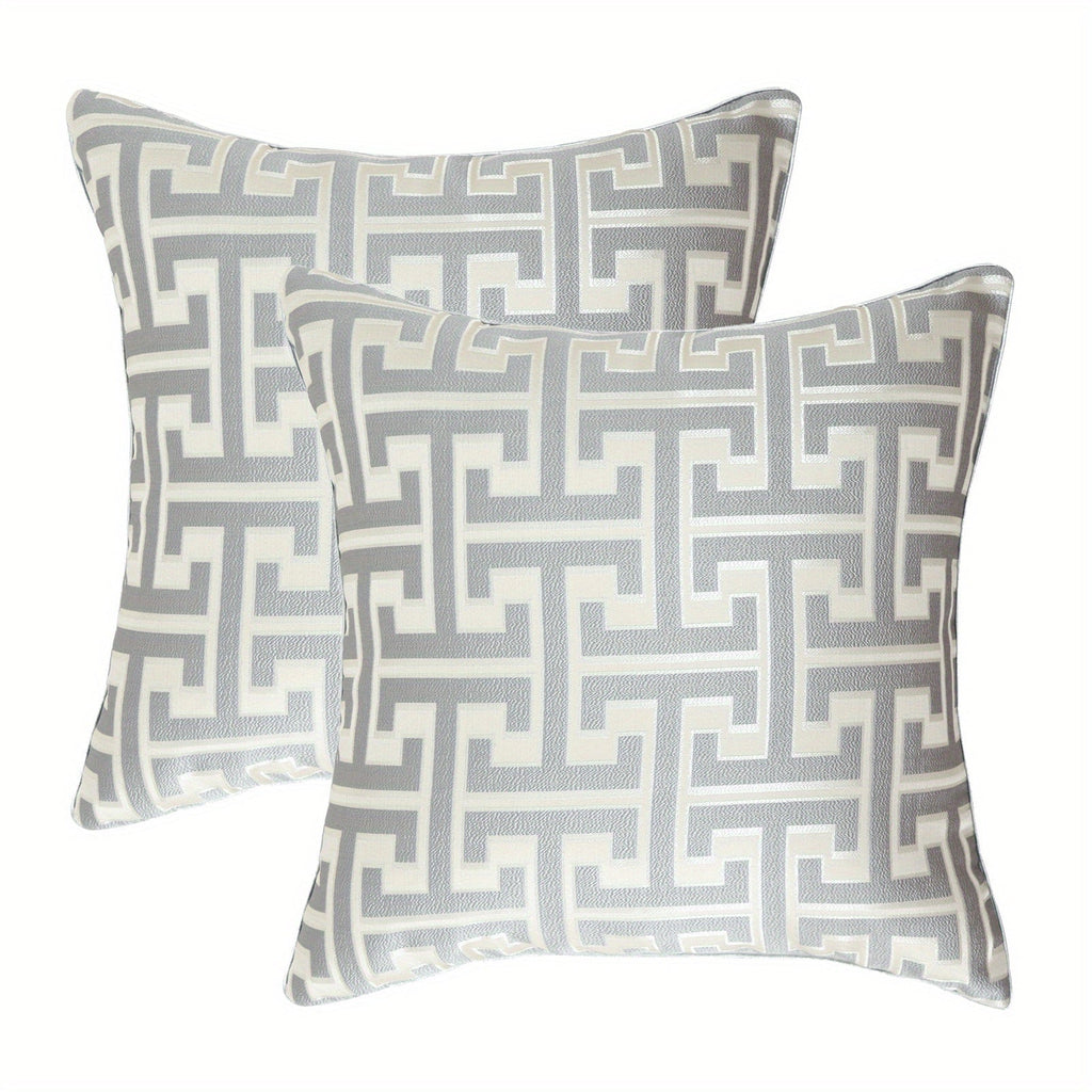 Two decorative pillows with geometric pattern on a white background