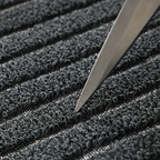 Close-up of a textured black surface with a sharp object on top