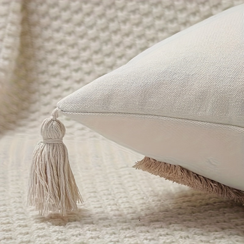 Beige pillow with tassel on a textured surface